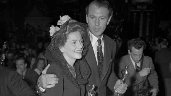 Hollywood stars Joan Fontaine and Gary Cooper holding their Oscars.