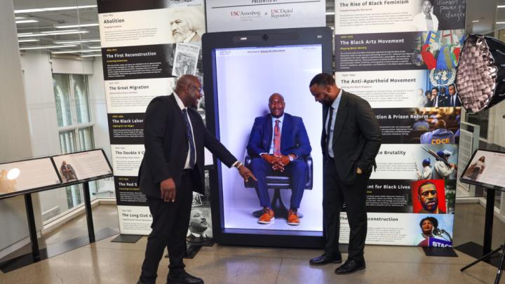 Philonise Floyd, left, marvels at the life-like quality of his Interactive Interview as he shares a laugh with Atty. S. Lee Merritt. Both men are featured in the Second Draft Project‘s police brutality oral history collection, and visited USC Annenberg School to debut their respective holograms this month.